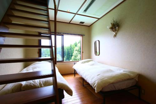 南阿苏村Tsukitei的一间带两张双层床的卧室和楼梯