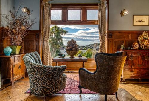 奥玛鲁山顶奢华庄园的客厅设有大窗户和两把椅子