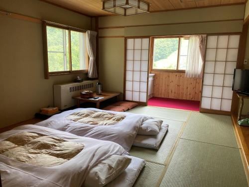 山之内町滋贺阿斯彭酒店的一间带两张床的卧室,位于带窗户的房间内