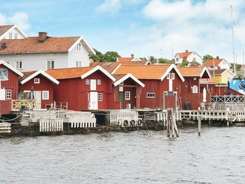 Hälleviksstrand6 person holiday home in H LLEVIKSSTRAND的一群水边的红房子