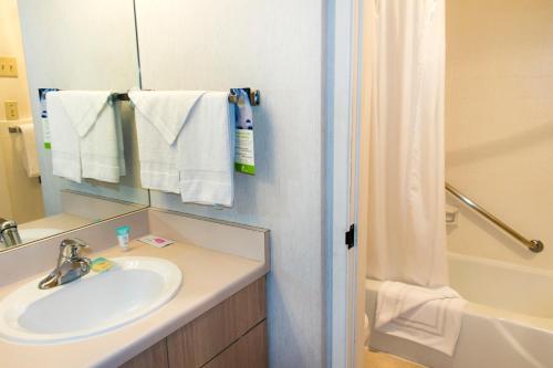圣地亚哥The Beach Cottages的浴室配有盥洗盆、镜子和浴缸
