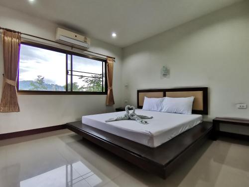 Ban NaiNestvilla Khok-kloi Phang-nga的卧室配有一张大白色床和窗户