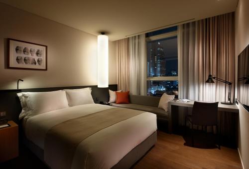首尔Shilla Stay Seocho Gangnam Station的酒店客房设有一张大床和一张沙发。