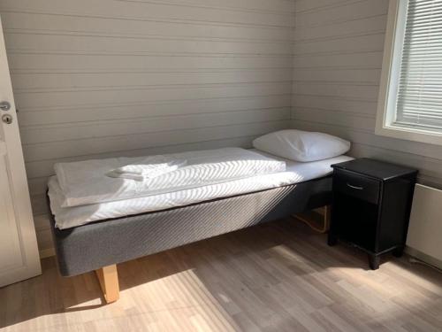 Sjøvegan贾斯尼布里格度假屋的一张小床,位于一个设有床头柜的房间