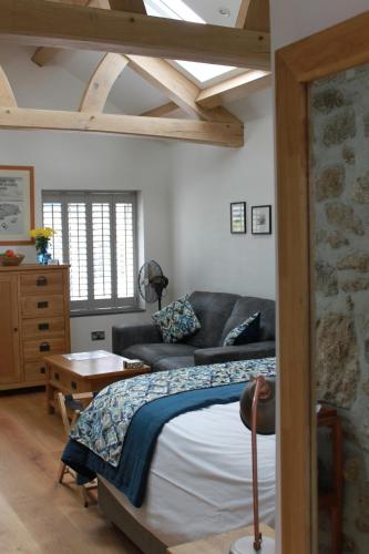PaulBryher Cottage的一间卧室配有一张床和一张沙发