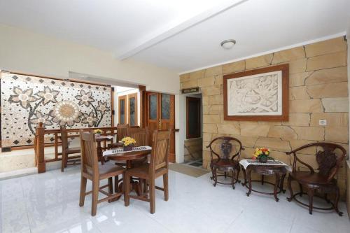 日惹Hotel Mataram Malioboro的配有桌椅和石墙的房间