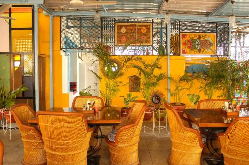 焦特布尔Moustache Jodhpur的餐厅设有桌椅和黄色的墙壁