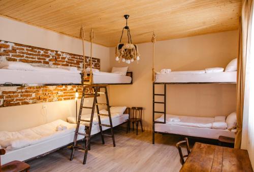 卡兹贝吉Home Kazbegi的客房设有三张双层床和木制天花板。