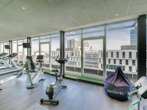 科隆科隆诺沃特酒店的一间健身房,透过窗户可欣赏到城市美景