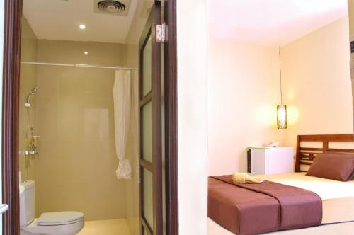 库塔库塔纱丽楼酒店的一间带一张床、淋浴和卫生间的浴室