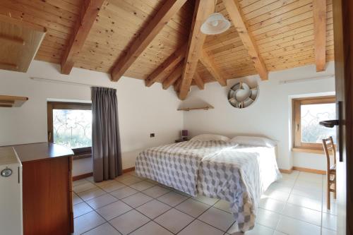 阿科Residenza Mariella的一间卧室设有床铺和木制天花板