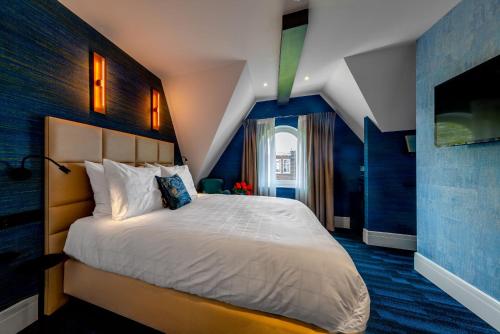 阿姆斯特丹De Ware Jacob Boutique Hotel的一间卧室配有一张带蓝色墙壁的大床