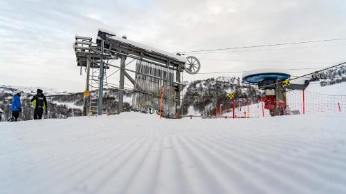 VågsliHaukelifjell Skisenter的雪覆盖的滑雪坡顶上的滑雪缆车