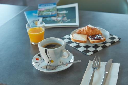 RuaudinAshley Hotel Le Mans Sud的一杯咖啡和一盘面包及橙汁