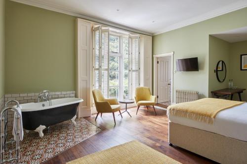 纽波特小修道院酒店的卧室配有床和浴缸