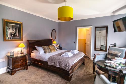 海斯Port Lympne Mansion Hotel的卧室配有1张床、1张桌子和1把椅子