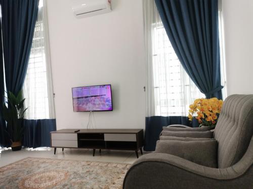 阿罗士打Damai Homestay Alor Setar的客厅配有蓝色窗帘和电视