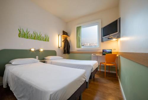 圣保罗ibis budget SP Frei Caneca的酒店客房设有两张床、一张书桌和一个窗户。