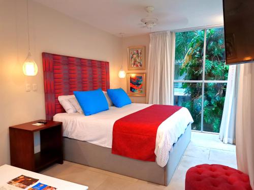 曼努埃尔安东尼奥Jungle Vista Boutique Hotel的一间卧室配有一张带红色床头板的床和窗户