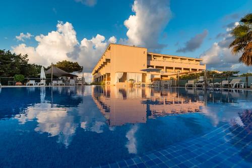 埃斯普霍斯Hotel Tahiti的大楼前有游泳池的酒店