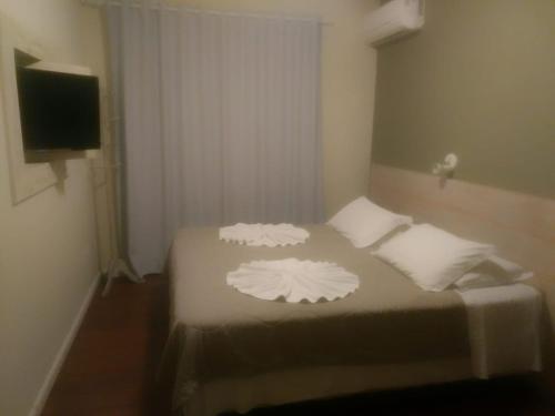 弗洛里亚诺波利斯阿尔沃雷多港旅馆的一间卧室配有一张带两个白色枕头的床