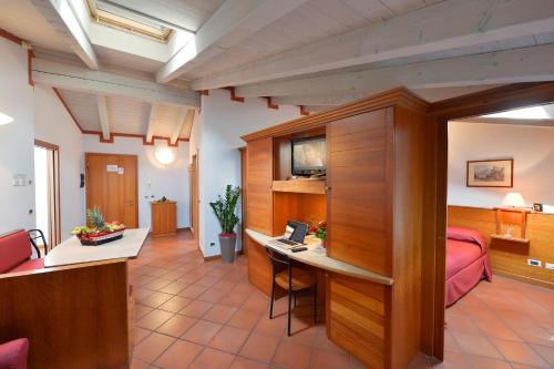 罗韦雷托德尔米萨杰罗公寓的客房设有一张床、一张桌子和一台笔记本电脑