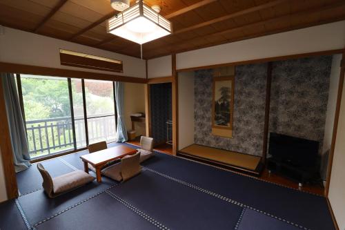 箱根Onsen & Garden -Asante Inn-的客厅配有桌子和电视