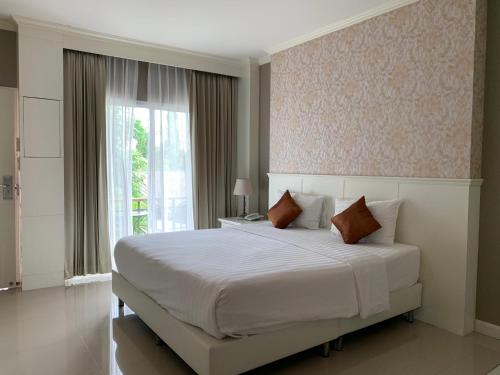 清莱清莱宿舍之家旅馆的卧室设有一张白色大床和一扇窗户。