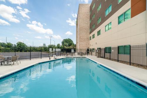 亚特兰大Holiday Inn Express & Suites Atlanta Airport NE - Hapeville, an IHG Hotel的大楼前的游泳池