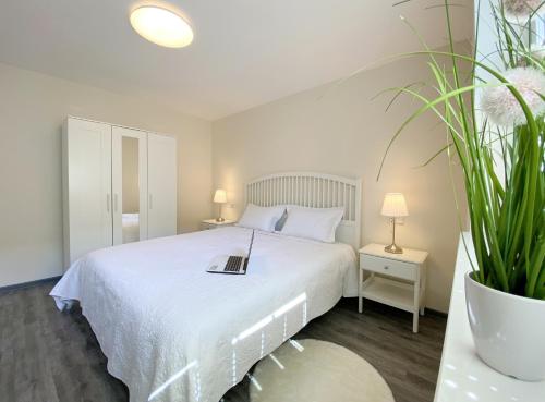 韦尼格罗德REGIOHOTEL Aparthotel Wernigerode的卧室配有一张白色的床,上面有书