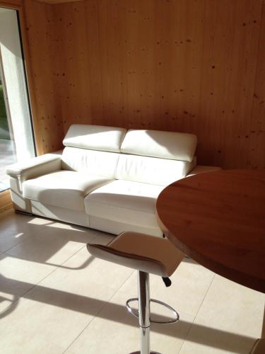 阿德尔博登2-Zimmer Ferienwohnung,Parterre,Sitzplatz,Garage的一张白色沙发,位于带桌子的房间