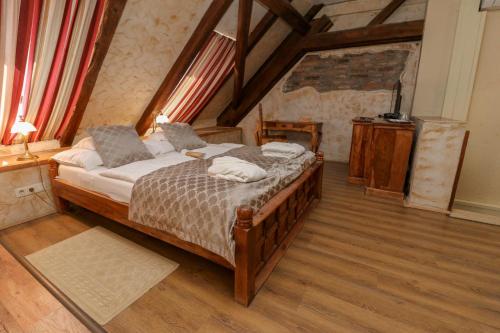 比考尔Puchner Kastélyszálló的一间卧室配有一张床,铺有木地板