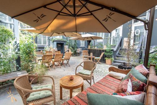 柏林露露格尔德梅登酒店的庭院配有桌椅和遮阳伞。