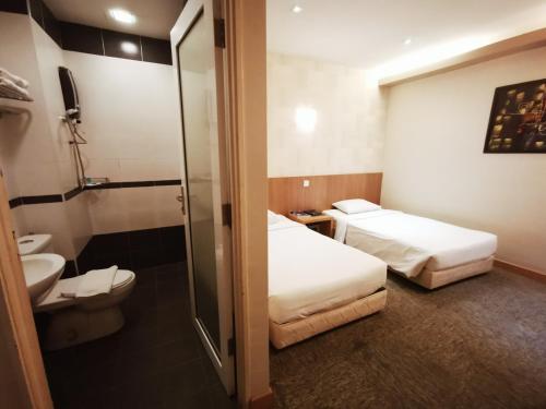 吉隆坡Prescott Hotel Bukit Bintang的酒店客房设有两张床和卫生间。