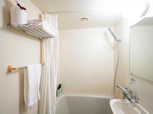 延冈市诺贝卡地区酒店 的浴室配有白色浴缸和水槽