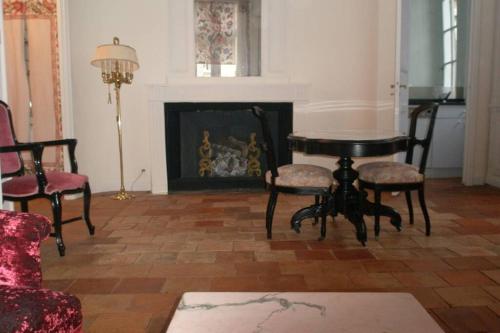 图卢兹Logis de Sainte-Scarbes的客厅配有桌椅和壁炉