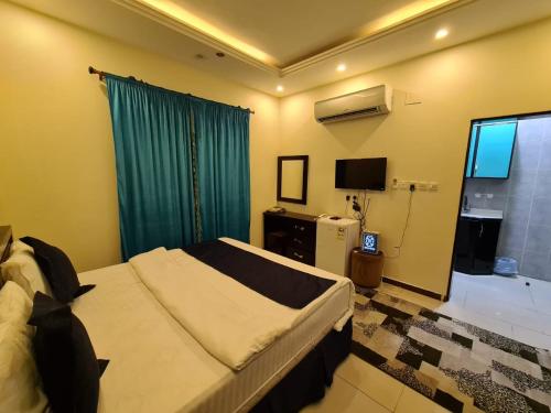 麦加瑞卡兹公寓式酒店的一间卧室配有一张大床和电视