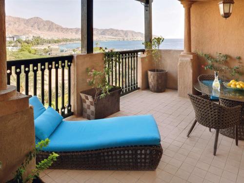 亚喀巴亚喀巴莫温匹克度假公寓的阳台配有桌椅,享有海景。