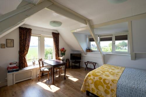 海勒富特斯勒斯兰德勒文住宿加早餐旅馆的卧室配有一张床、一张书桌和窗户。