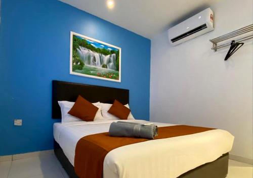 雪邦Hotel EC Double Star KLIA 1-KLIA 2的一间卧室配有一张蓝色墙壁的床