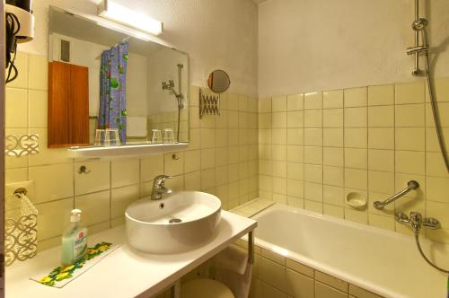 巴特克罗青根巴仁酒店的浴室配有盥洗盆和浴缸。