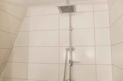 文尼希森卡林贝格霍夫酒店的浴室设有白色瓷砖淋浴。