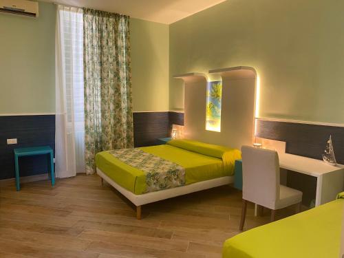焦维纳佐Porto di mare b&b的一间卧室配有一张床、一张桌子和一张书桌
