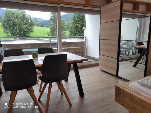 埃尔毛Berghof Apartment Bergwiese Top 31的客房设有桌椅和大窗户。