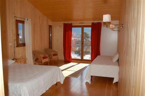 Plan dʼAups红色庄园旅馆的一间卧室设有两张床,窗户配有红色窗帘