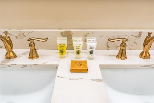 新奥尔良The Alexandre的浴室设有金色水龙头和水槽玻璃杯
