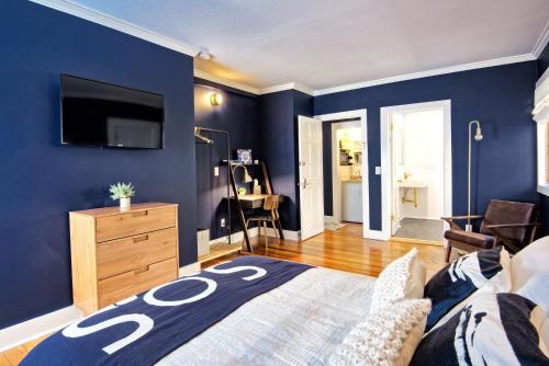 哈德逊Nautical Nest Hudson的一间带蓝色墙壁、一张床和电视的卧室