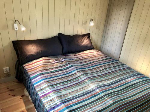 KlövedalMysig nybyggd stuga nära hav och natur的一张带五颜六色的被子的床