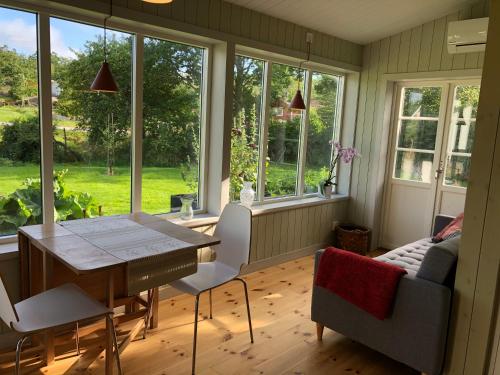 KlövedalMysig nybyggd stuga nära hav och natur的一间带桌椅和窗户的用餐室