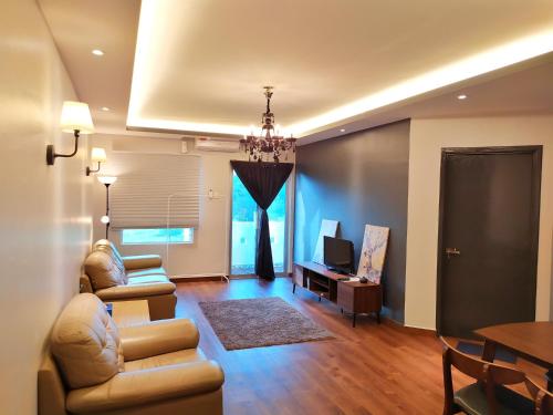 迪沙鲁D'Ocean Homestay in Tiara Desaru Residence的带沙发、电视和桌子的客厅
